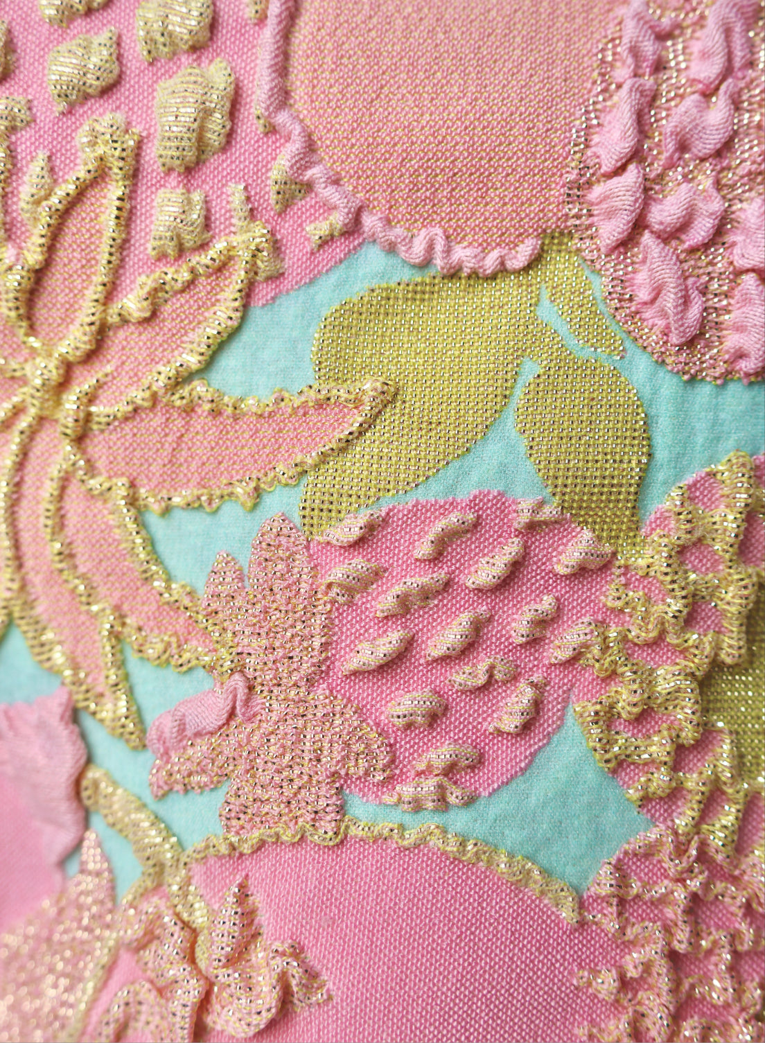 close up of pink, blue and gold jacquard swimsuit fabric texture