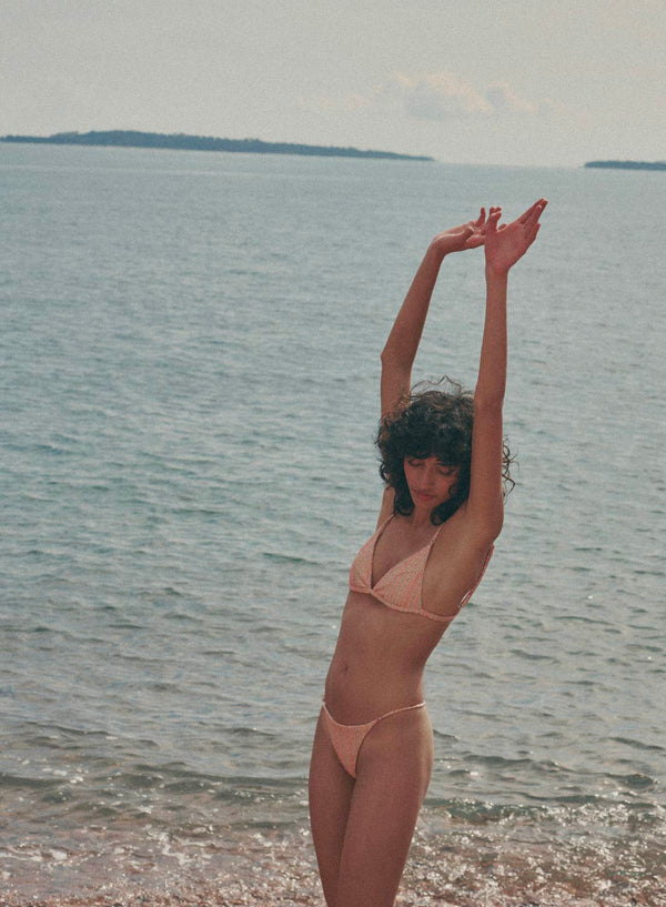 model is wearing orange bikini with thin straps in jacquard fabric, front view