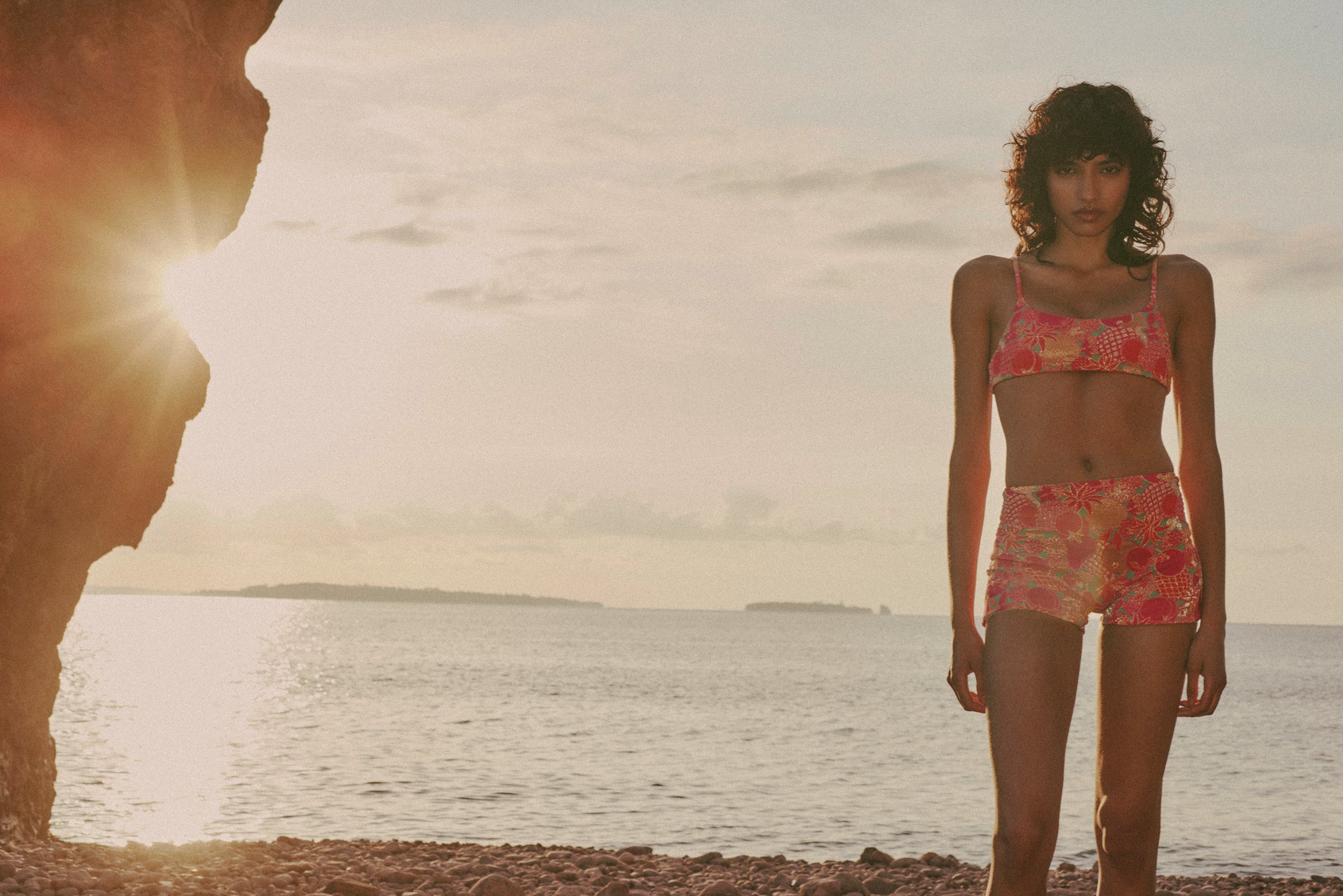 Model wearing MAYANNA SS26 floral jacquard bikini set on the coast of Théoule-sur-Mer