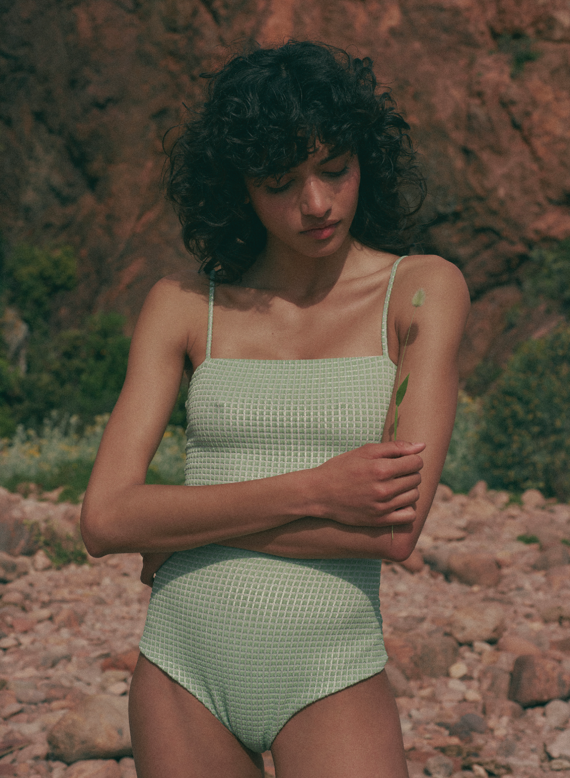 model is wearing green one-piece swimsuit with square neckline and thin straps in jacquard fabric, front view
