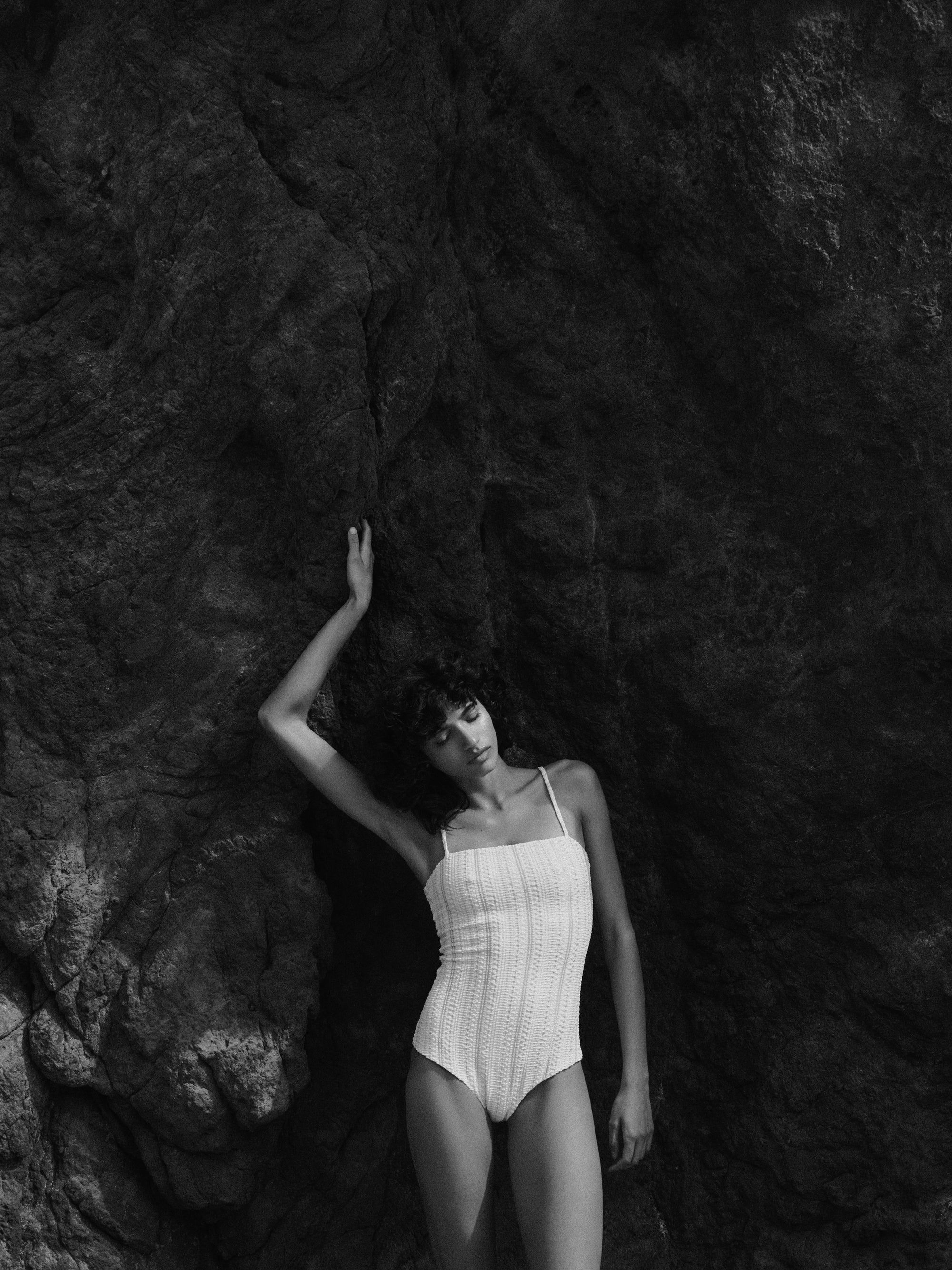 model is wearing white one-piece swimsuit with thin shoulder straps in jacquard fabric,  full coverage, front view