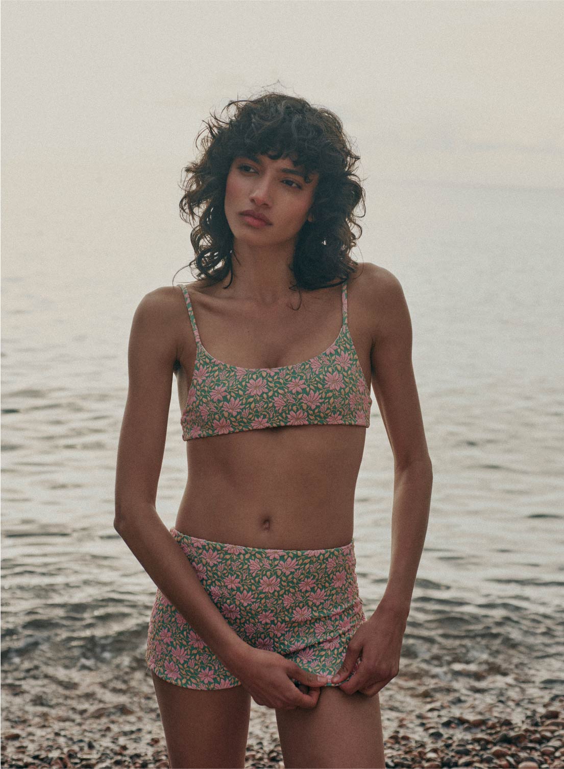 model is wearing green and pink floral bikini bottom swimsuit shorts in jacquard fabric, full coverage 